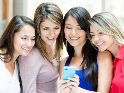 women sharing content on a phone