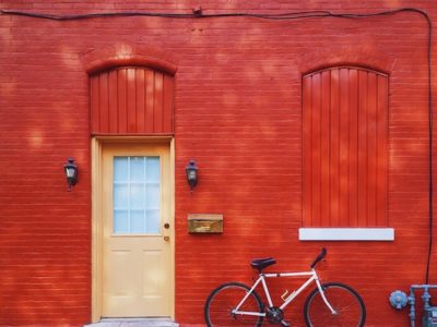 red brick wall, orange door and bicycle