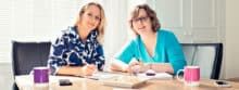 Leeann Stevenson and Jo Waltham sitting at a desk