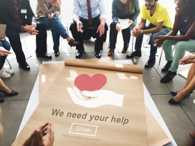 people sitting around a charity poster